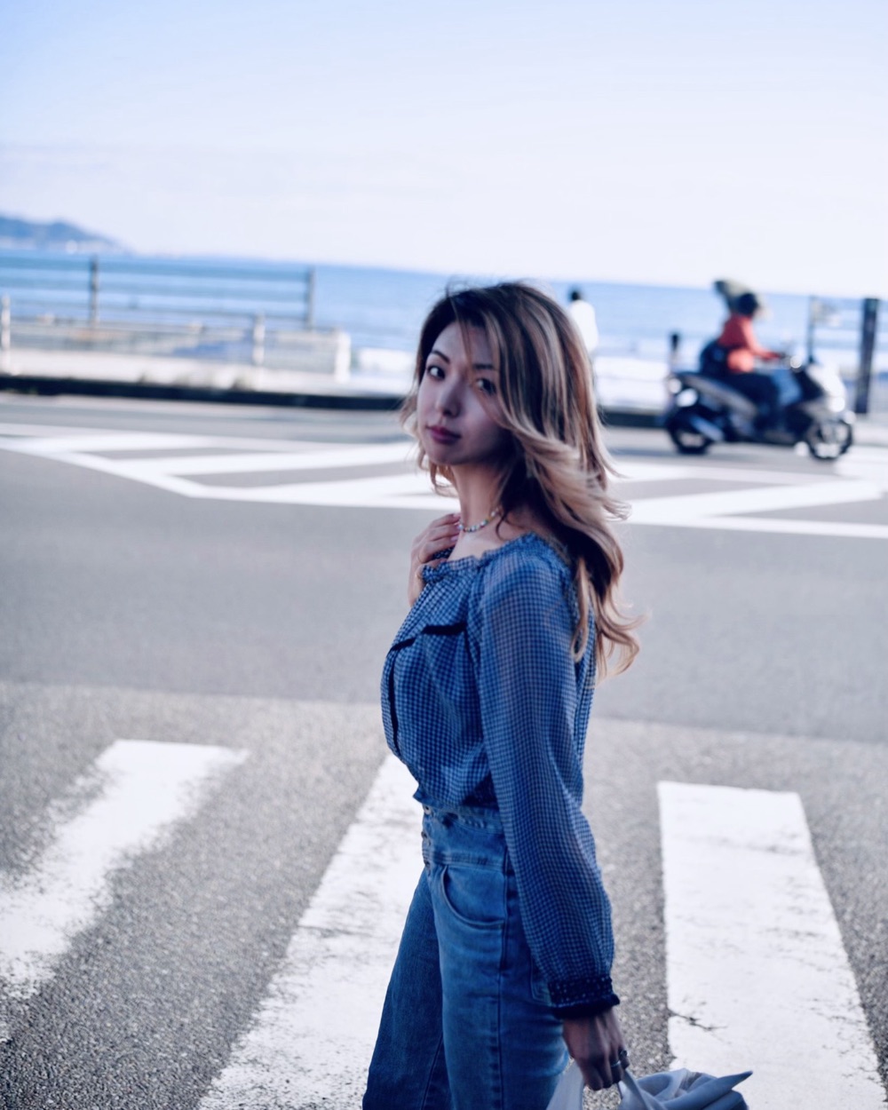 吉田奈未在海邊道路上回頭看